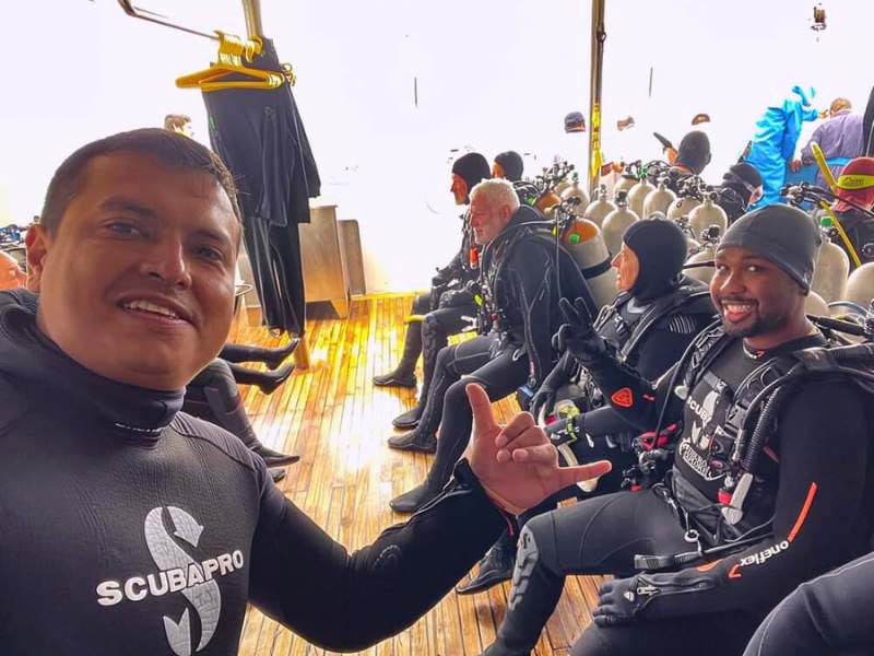 Wild George interacting with a group of divers on a dive boat, preparing for an unforgettable underwater adventure