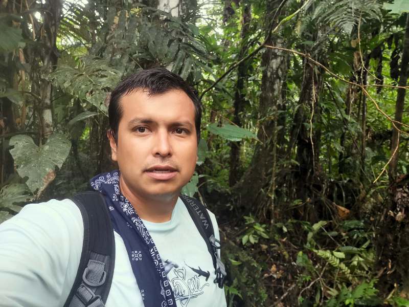 Wild George trekking through the dense Amazon rainforest, surrounded by vibrant greenery.